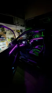 Iluminare violet pe bord și portiere, văzută prin ușa deschisă.